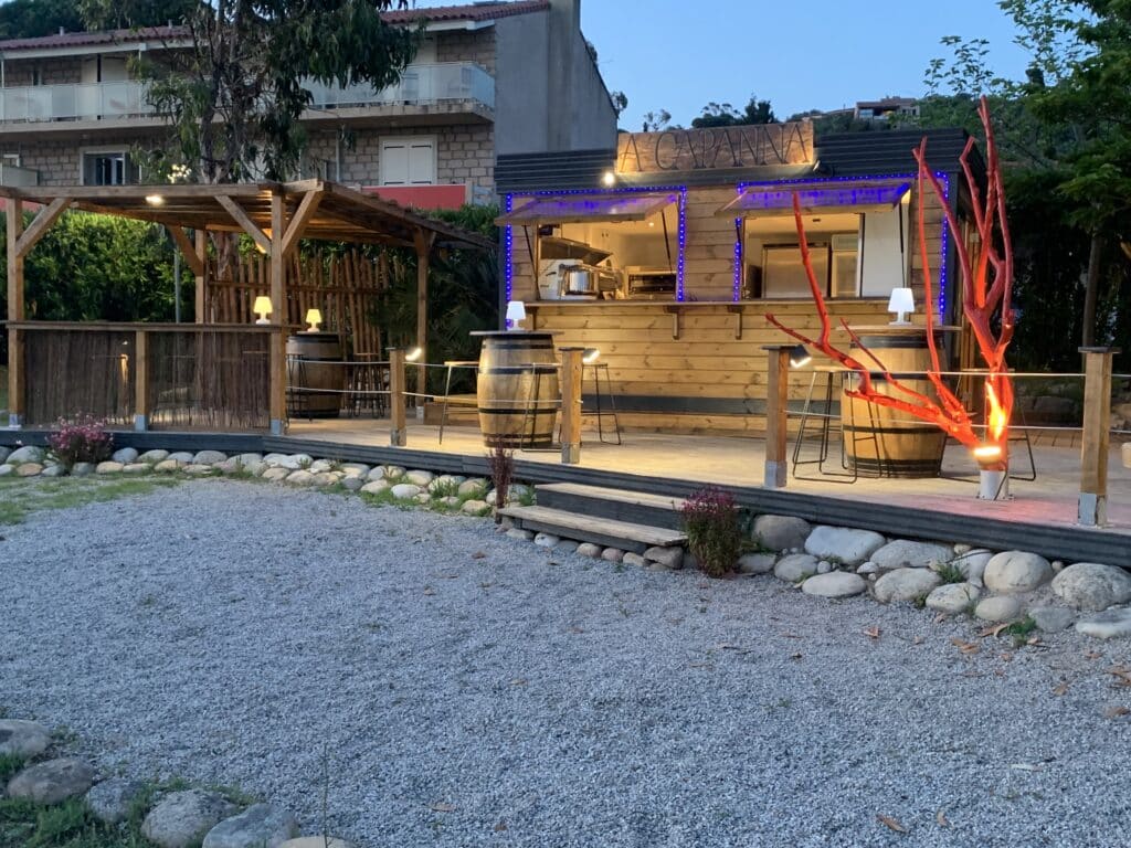 Abri jardin en bois aménagé en kiosque à pizza, installation client avec terrasse et mobilier extérieur