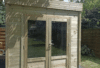 a wooden shed with glass doors - abri de jardin