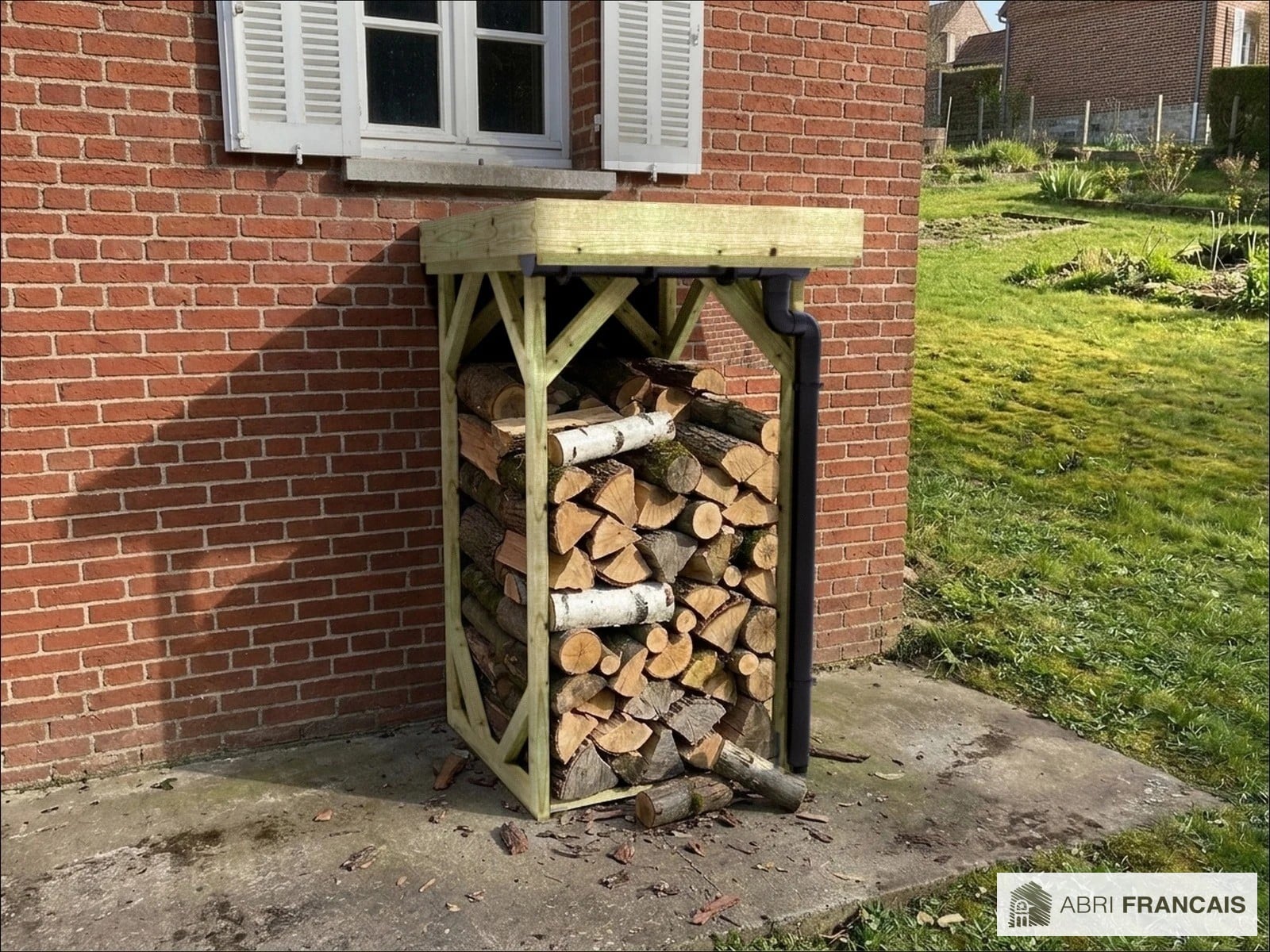 Abri à bûches 1 m × 1,30 m, adossé, avec gouttière – mise en situation