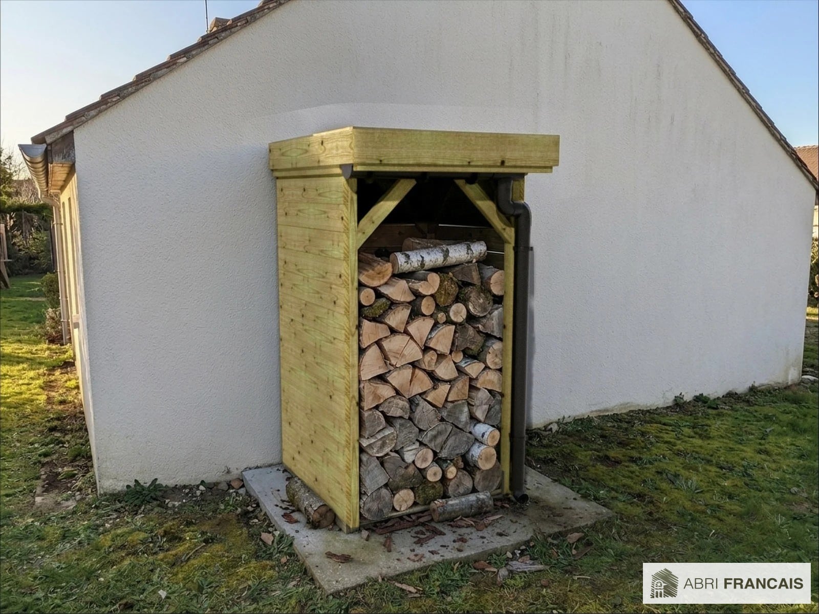 Abri à bûches 1 m × 1,30 m, adossé, avec gouttière – mise en situation