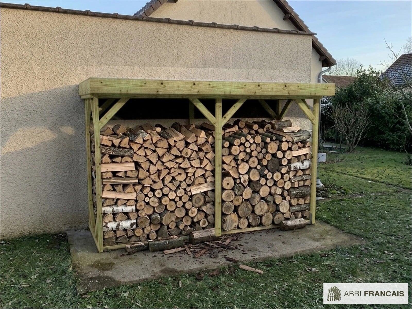 Abri à bûches 3 m × 1,30 m, adossé – mise en situation