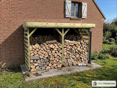 Abri à bûches 3 m × 1,30 m, adossé, avec gouttière – mise en situation