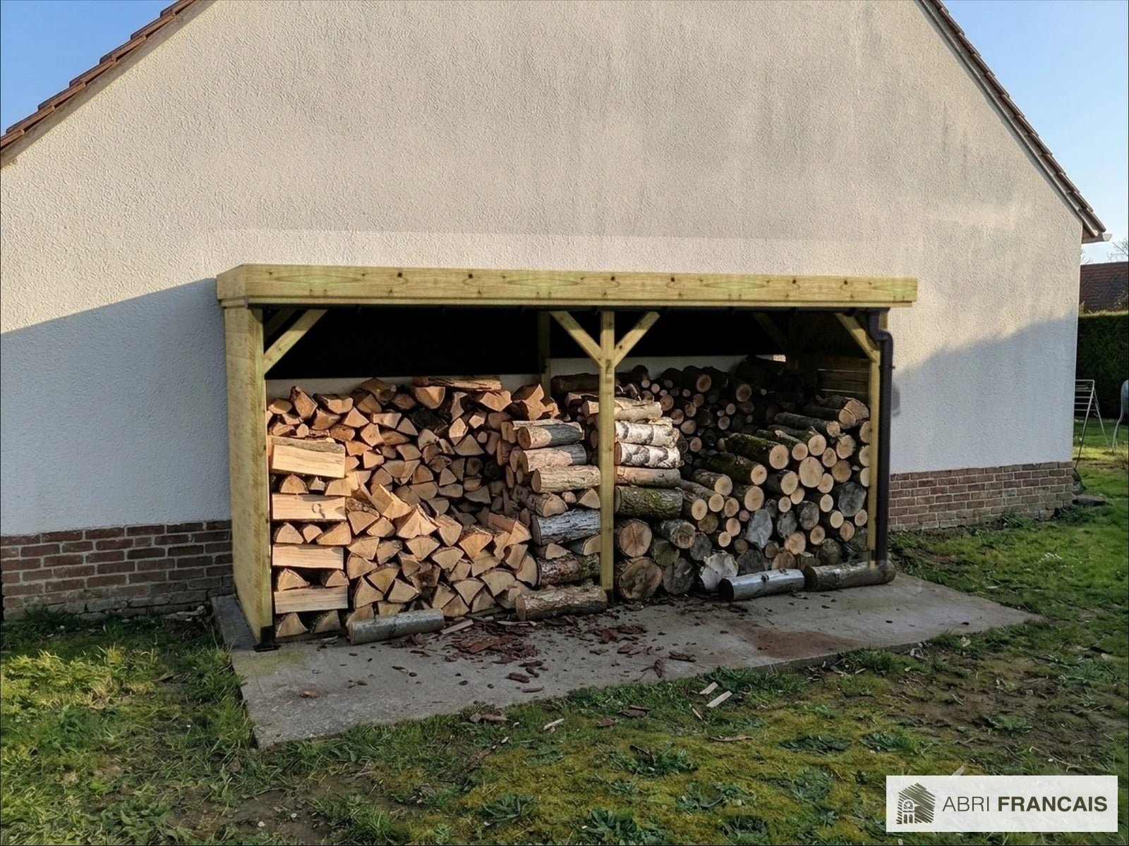 Abri à bûches 4 m × 1,30 m, adossé, avec gouttière – mise en situation